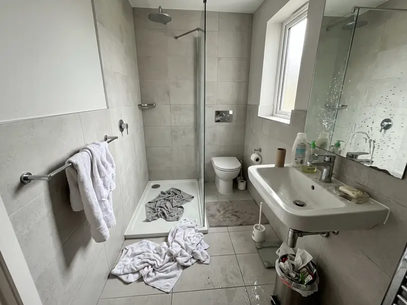 Bad einer Ferienwohnung mit benutzten Handtüchern nach der Abreise